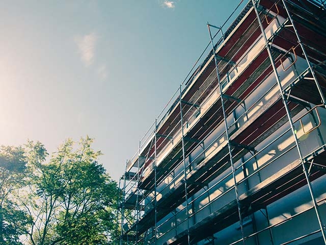 Ein Gebäude mit Baugerüst als Zeichen für Modernisierung.